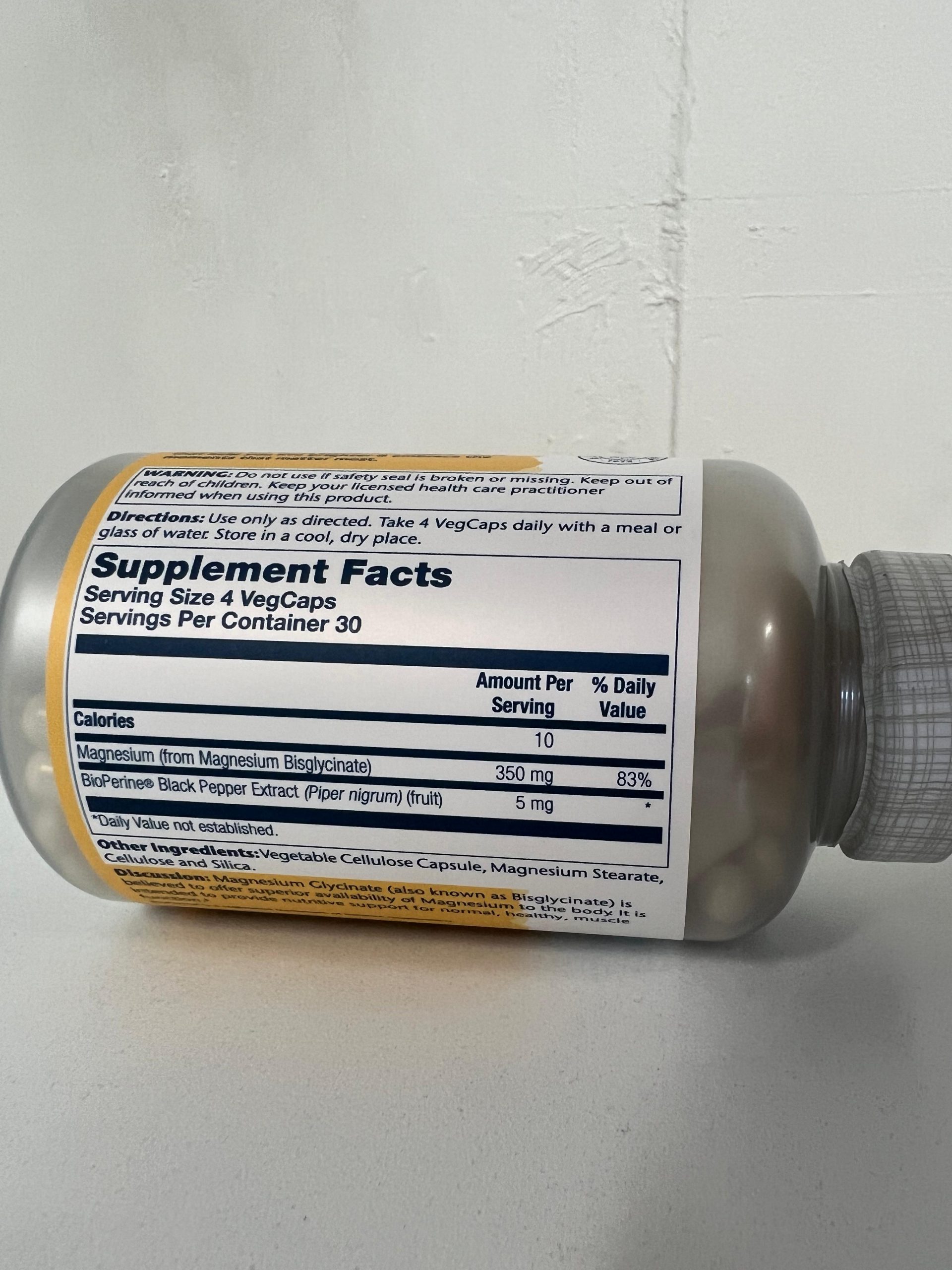 A side view of a Solaray Magnesium Glycinate supplement bottle showing the Supplement Facts panel. The label states a serving size of 4 vegetable capsules with 30 servings per container. Each serving contains 350 mg of magnesium from magnesium bisglycinate and 5 mg of BioPerine black pepper extract. Directions recommend taking 4 capsules daily with a meal or glass of water.